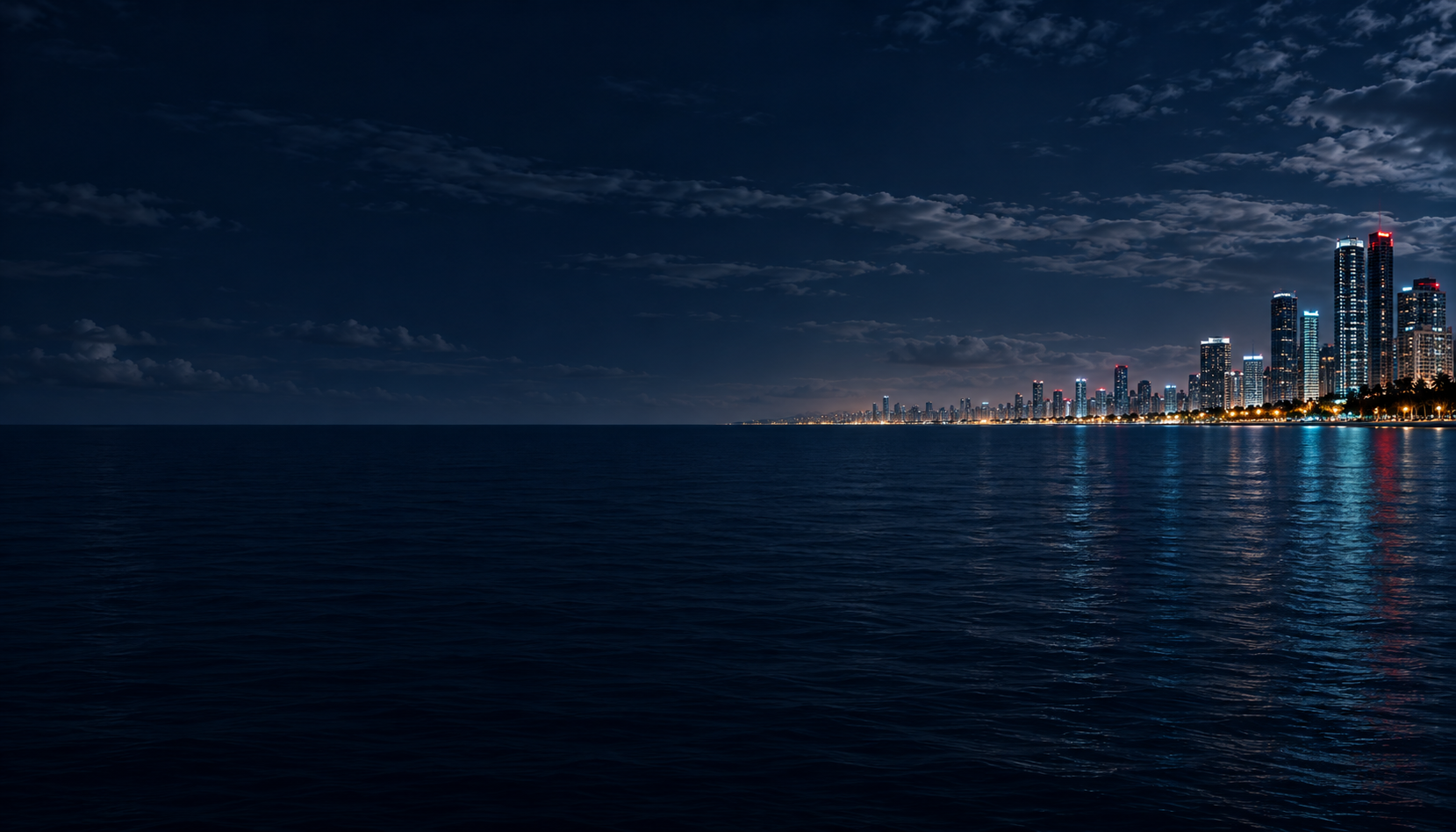Costa de Nueva Ola con la ciudad iluminada y el mar de noche